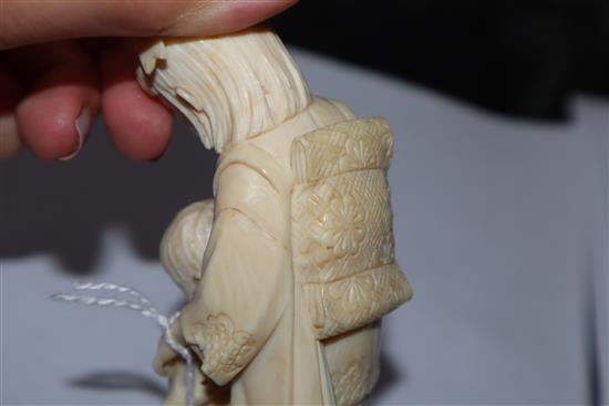 A Meiji carved ivory group of two children (damaged) on hardwood stand and a smaller group tallest 14cm incl. stand